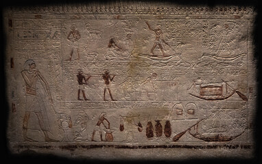 An Egyptian stone tablet isolated on a black background, on which scenes from mythology are drawn,...