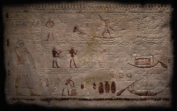 An Egyptian stone tablet isolated on a black background, on which scenes from mythology are drawn, and numerous hieroglyphs, symbols and inscriptions are engraved.