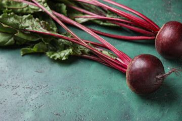 Fresh beetroots with leaves on green table