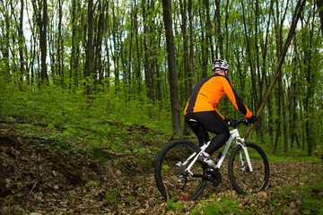 Fototapeta premium Biker in orange jersey on the forest road