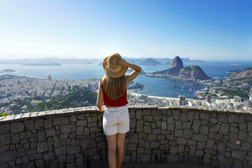 Travel in Rio de Janeiro, Brazil. Rear view of tourist girl enjoying sight of famous Guanabara Bay...