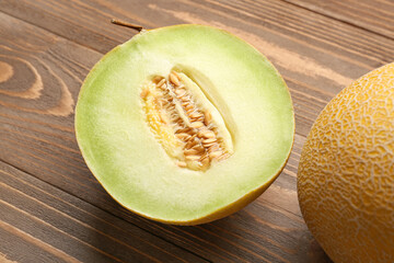 Sweet melon with half on wooden background