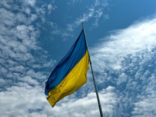 National flag of Ukraine. The flag of the Ukrainian state against the background of the sky. Blue-yellow national symbol of Ukraine. The concept of peace and support for Ukraine against Russian aggres