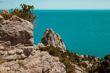 Top view of blue sea water with white waves and stones.