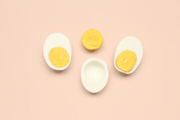 Halves of tasty boiled eggs on pink background