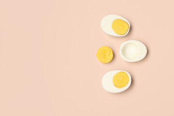 Halves of tasty boiled eggs on pink background