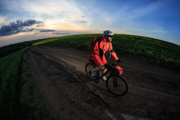 Obraz premium Man on mountain bike rides on the trail on a beautiful sunset. Wide view