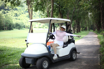 golfer riding golf cart on green lawn of golf field at warm sunny day.