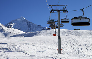 Fototapeta na wymiar Chair lift in snowy mountains at nice sunny day. Caucasus Mountains. Mount Tetnuldi, Svaneti region of Georgia.