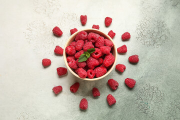 Bowl with fresh raspberry and mint on light background