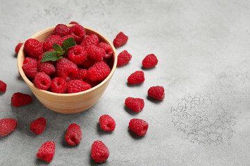 Bowl with fresh raspberry and mint on light background, closeup