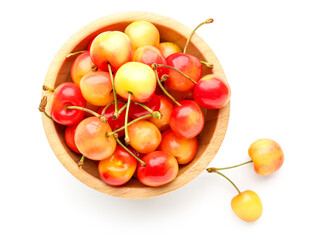 Bowl with sweet yellow cherries on white background