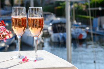 Summer party, drinking of French brut rose champagne sparkling wine in glasses in yacht harbour of Port Grimaud near Saint-Tropez, French Riviera vacation, France