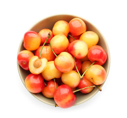 Bowl with sweet yellow cherries on white background