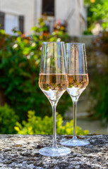 Tasting of premier cru sparkling rose wine with bubbles champagne with view on old houses of Hautvillers, where lived Benedictine monk how developed champagne wine, France.