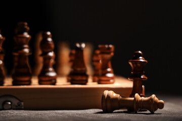 Game board with wooden chess pieces on dark background, closeup