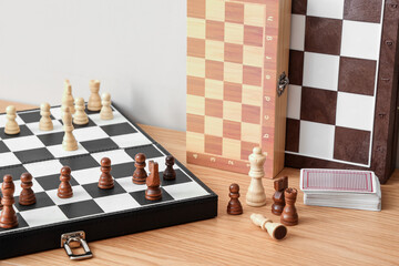 Chess boards on table near light wall