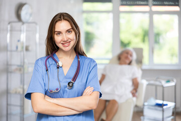 Portrait of friendly young female doctor with stethoscope, wearing uniform standing in treatment...