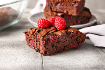 Piece of raspberry chocolate brownie on grey tile table