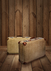 Two vintage suitcases on rough wooden plank background