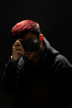 Young anonymous man taking photo on camera