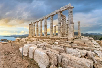Keuken foto achterwand Mediterraans Europa The Temple of Poseidon, an ancient Greek temple on Cape Sounion, Greece, dedicated to the god Poseidon, with the Aegean sea and coastline seen under early sunset dramatic skies. 