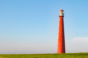 Beautiful Red Lighthouse under a blue sky shot at sunset in Den Helder, The Netherlands.