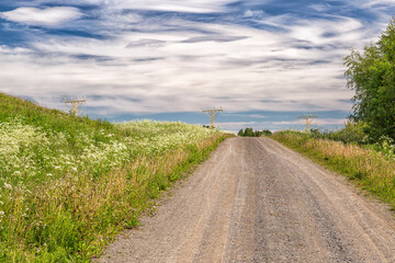 Fototapeta na wymiar Gravel Road and Approach Lighting System with a cloudy sky.