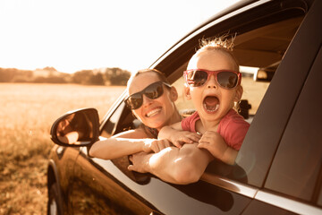 parent and child on vacation enjoying a road trip in a car, smiling and bonding