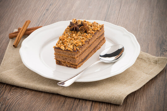 Chocolate cake on white plate over wooden table.