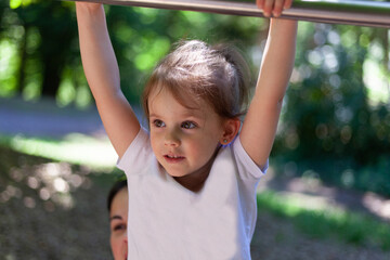 Fototapeta premium Portrait of a little girl on the playground. Selective focus.
