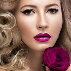 Fototapeta na wymiar Beautiful blonde in a Hollywood manner with curls, pink lips. Beauty face. Picture taken in the studio