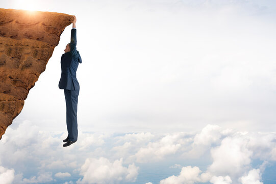 business concept challenge businessman clinging on