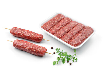 Fresh meat sausages in caserola with greens and spices isolated on white background. Meat food, top view