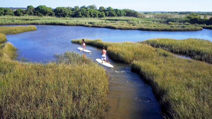 Man and woman stand up paddleboarding