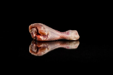 Fresh chicken drumstick and its reflection on the black background