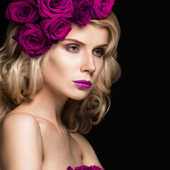 Fototapeta premium Beautiful blond girl in a dress and hat with roses, classic makeup, curls and red lips. Beauty face. Photos shot in studio