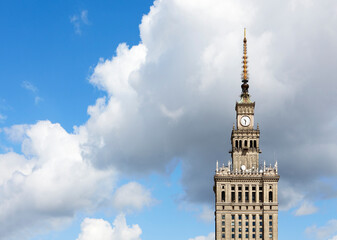 Fototapeta na wymiar The top of old skyscraper against the cloudy sky. Warsaw symbol.