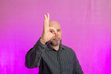 Portrait of bearded and bald man making signs with hands.