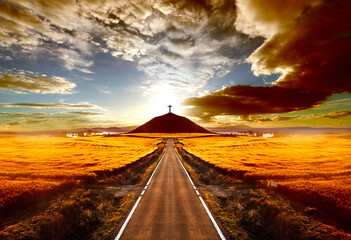 Adventures and road trips.Sunset and travel concept.Road and cross on the hill