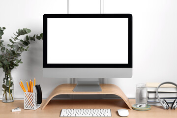 Cozy workspace with computer, headphones and stationery on wooden desk