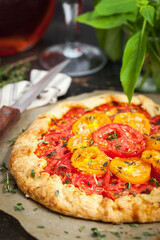 Delicious homemade rustic open pie (galette) with tomato, thyme and goat cheese