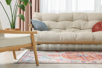 Beautiful rug, sofa and plant near window indoors