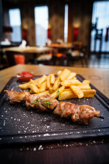 Barbecue grilled pork shashlik kebabs served with french fries