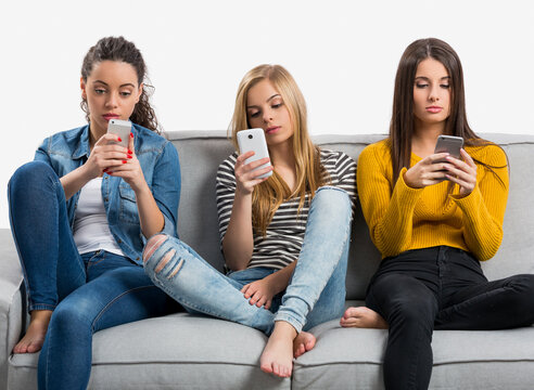 Happy teen girls at home using cellphone