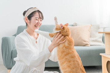 家で猫を抱っこする日本人女性（ペット・飼い主）
