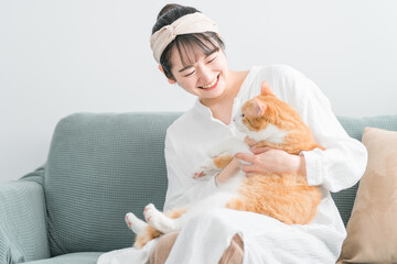 家で猫を抱っこする日本人女性（ペット・飼い主）
 - obrazy, fototapety, plakaty