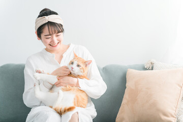 家で猫を抱っこする日本人女性（ペット・飼い主）
