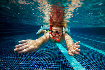 Man with snorkel mask and tube swim underwater in swimming pool