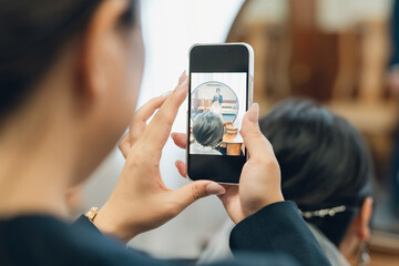 ブライズルーム・控え室で花嫁・新婦の写真をスマホで撮るプランナーの女性
